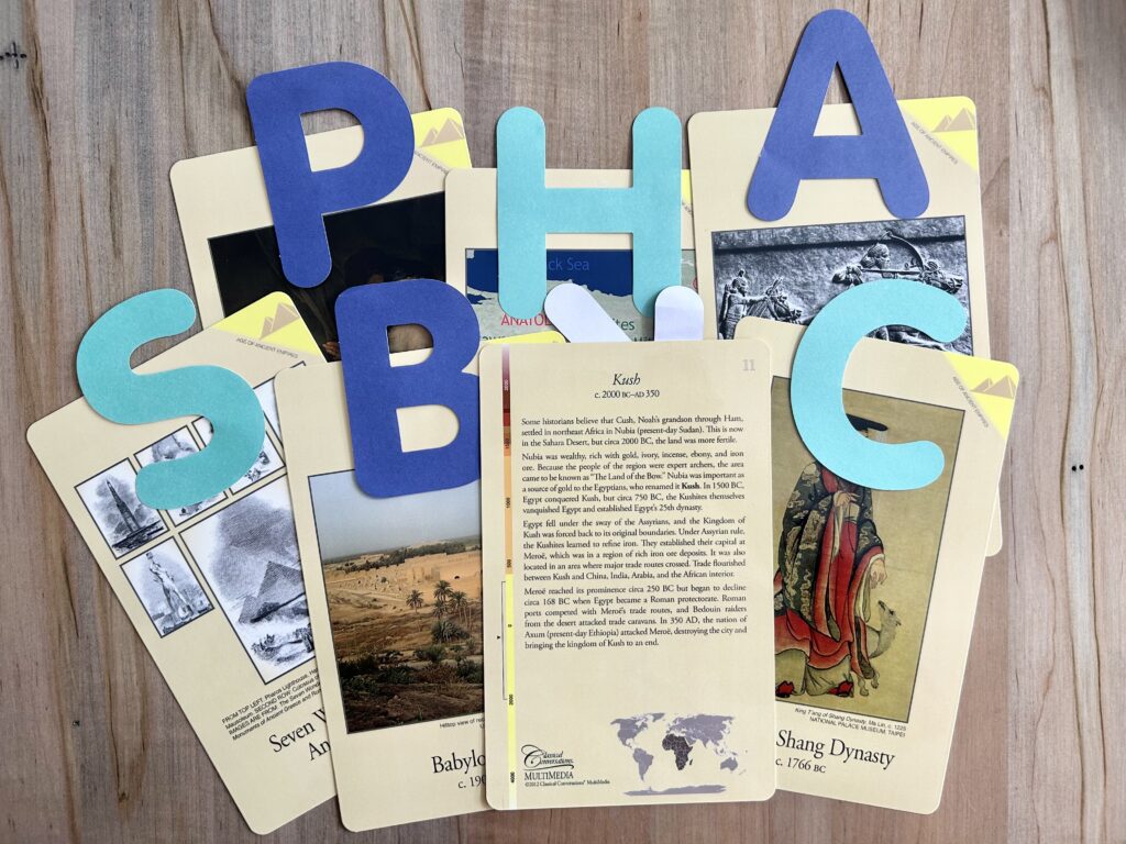 timeline cards with large paper letters on them face up and one card face down.